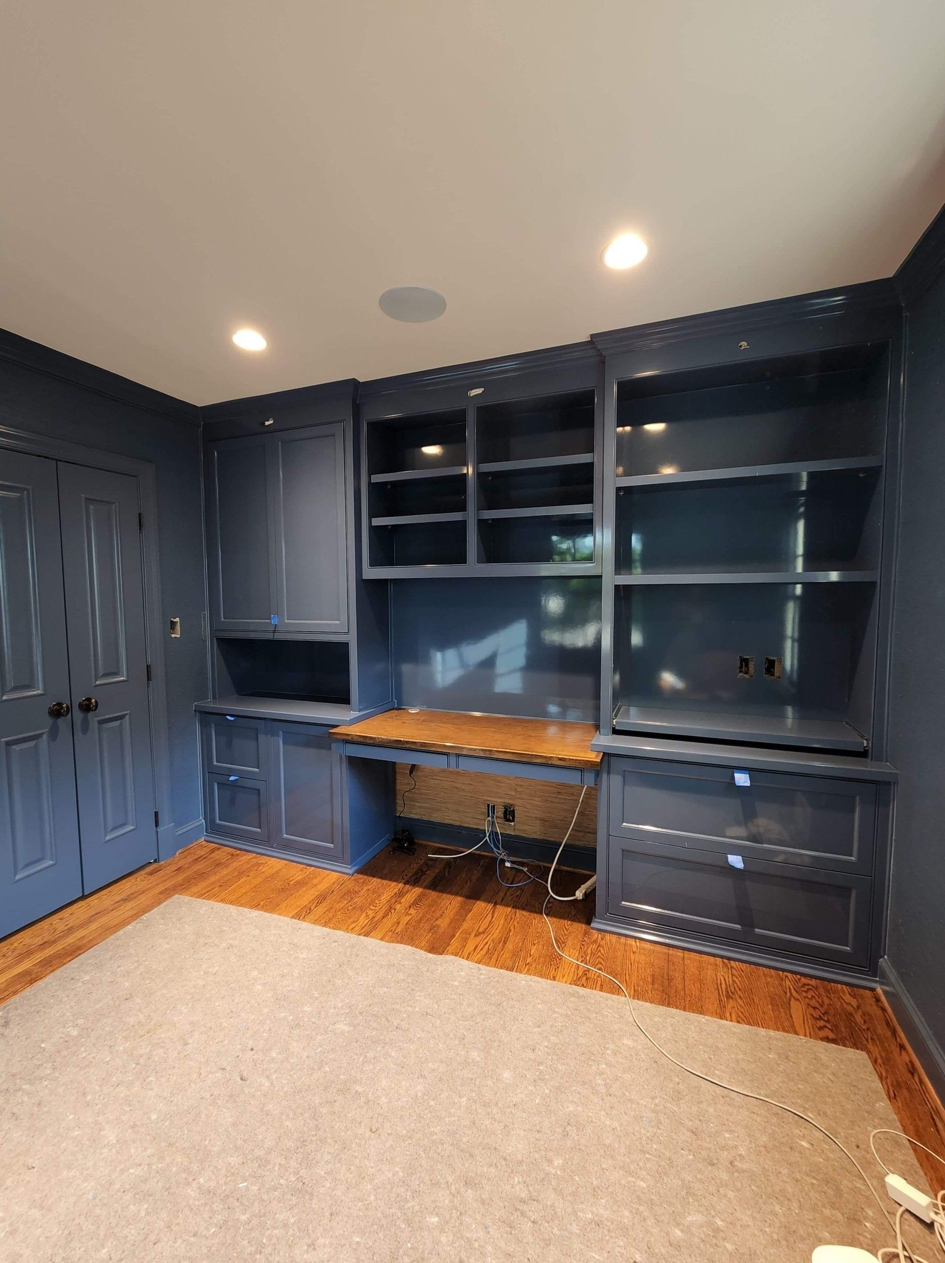 A room with a desk and shelves in it