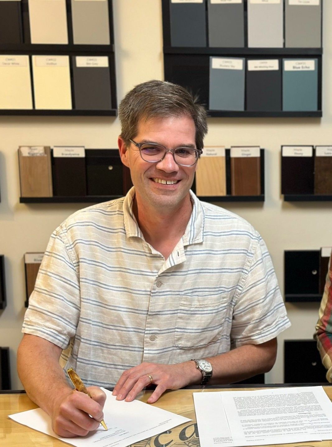A man is sitting at a desk writing on a piece of paper