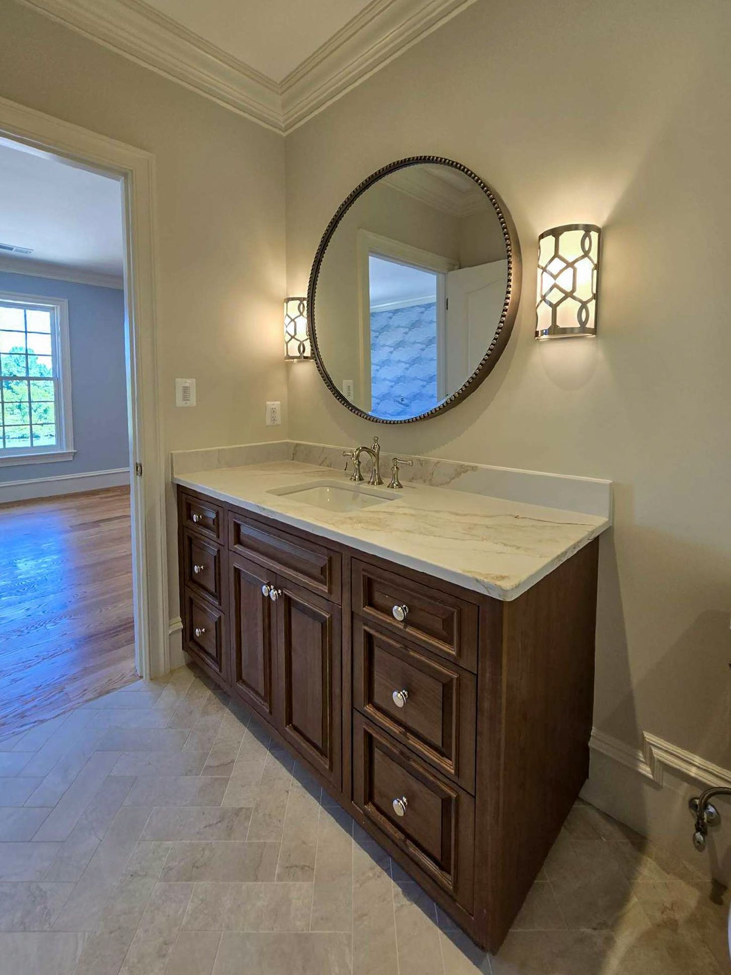 A bathroom vanity with a marble counter top and a sink