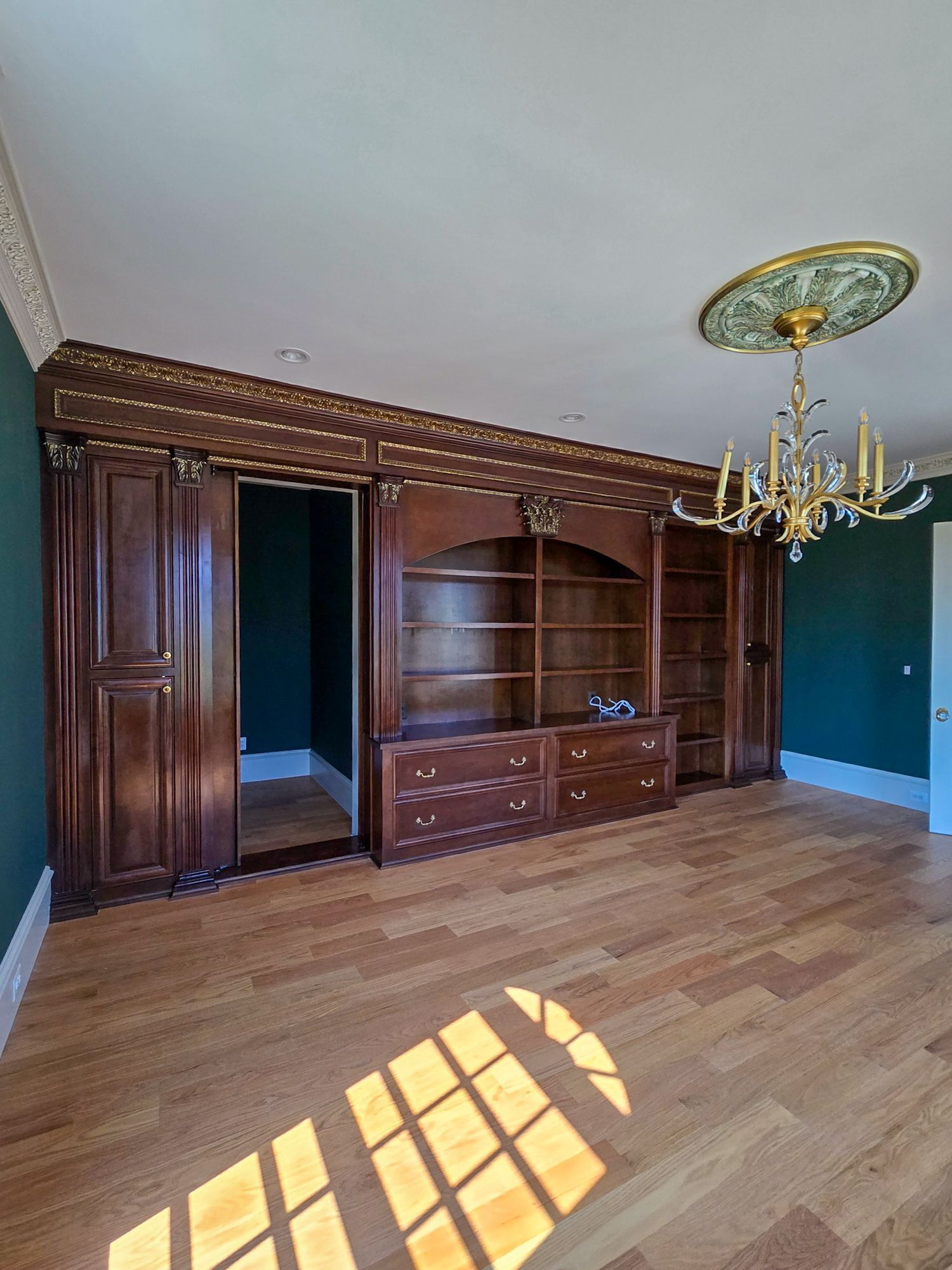 An empty room with a chandelier hanging from the ceiling