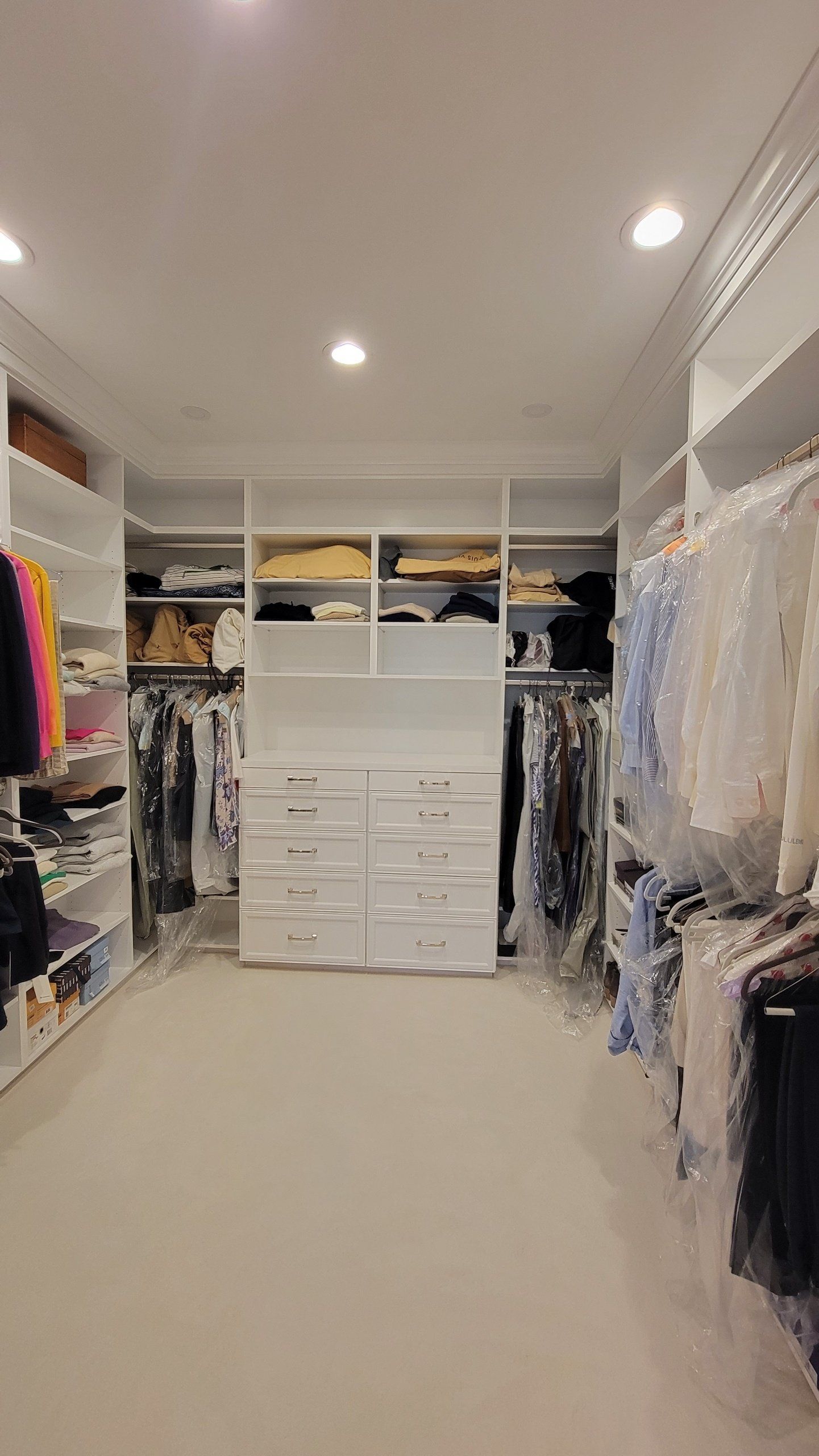 A large walk in closet filled with lots of clothes.