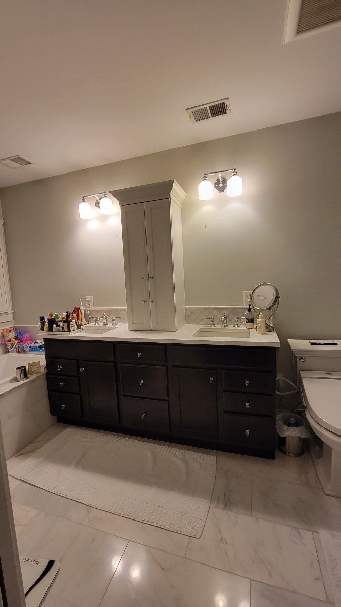 A bathroom with a toilet , sink , mirror and bathtub.