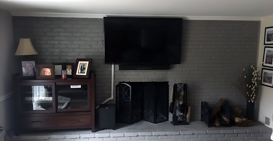 A living room with a fireplace and a flat screen tv