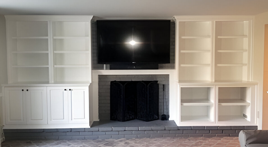 A living room with a fireplace , shelves , and a flat screen tv.