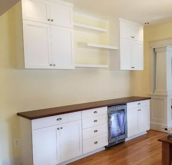 A kitchen with white cabinets and wooden counter tops