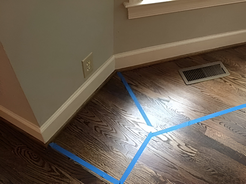 A corner of a room with blue tape on the floor