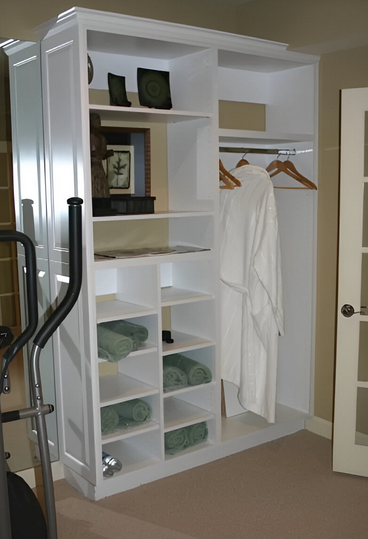 A white closet with a robe hanging on a hanger