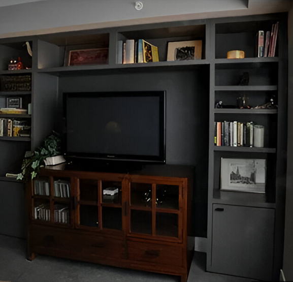 A large flat screen tv is sitting on a wooden entertainment center