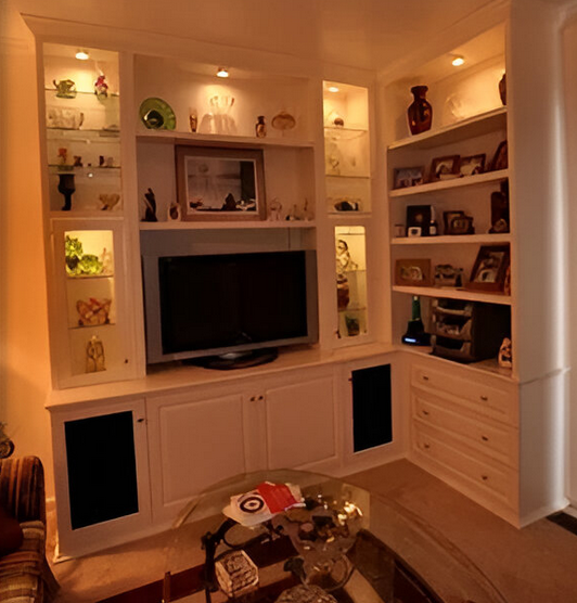 A living room with lots of shelves and a flat screen tv
