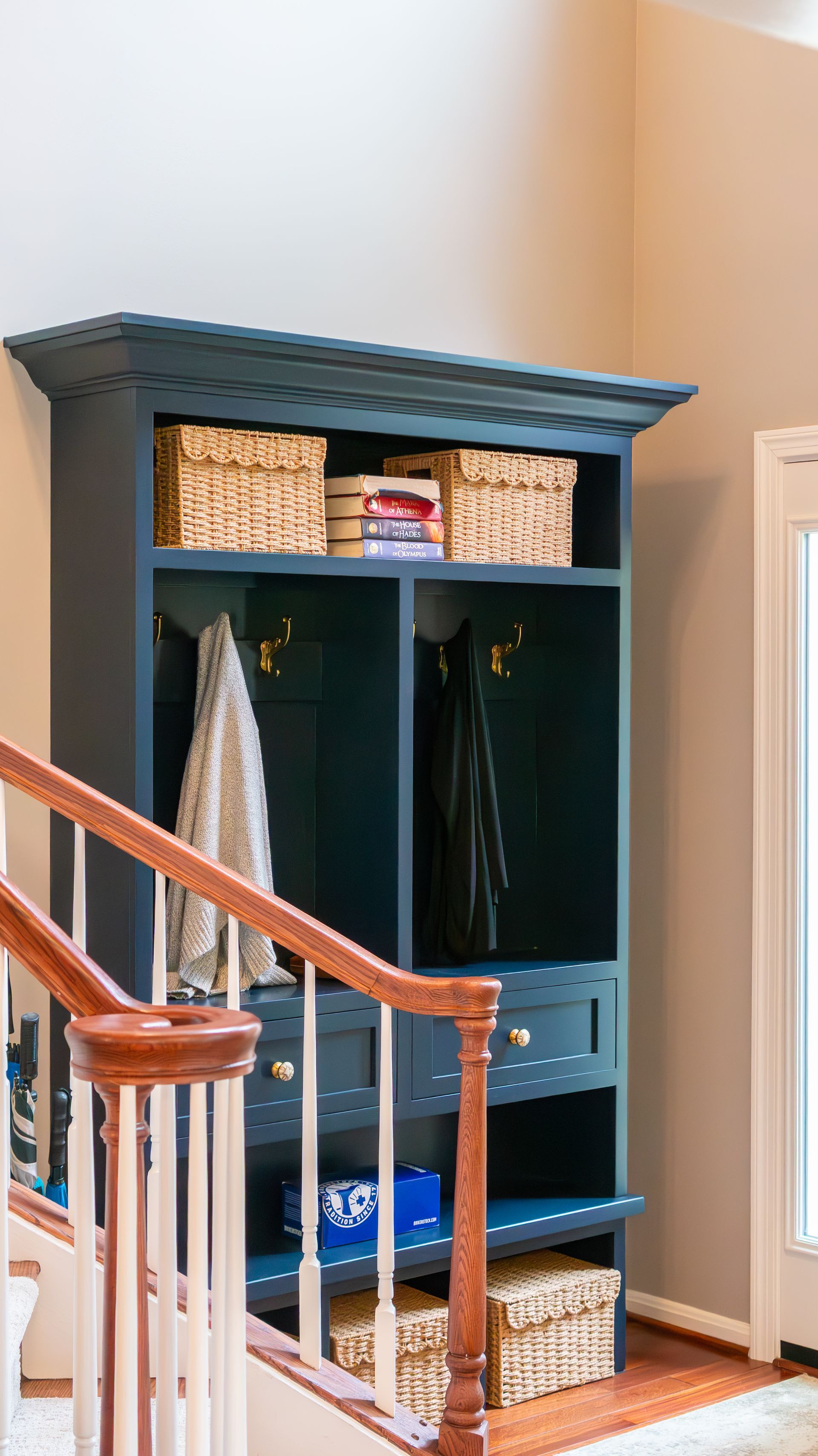 A staircase leading up to a blue shelf with baskets on it