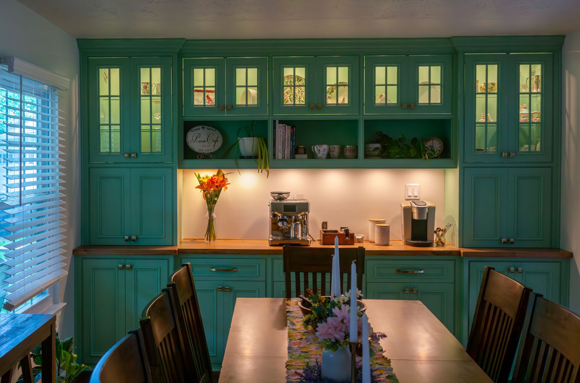 A kitchen with green cabinets and a table with candles on it