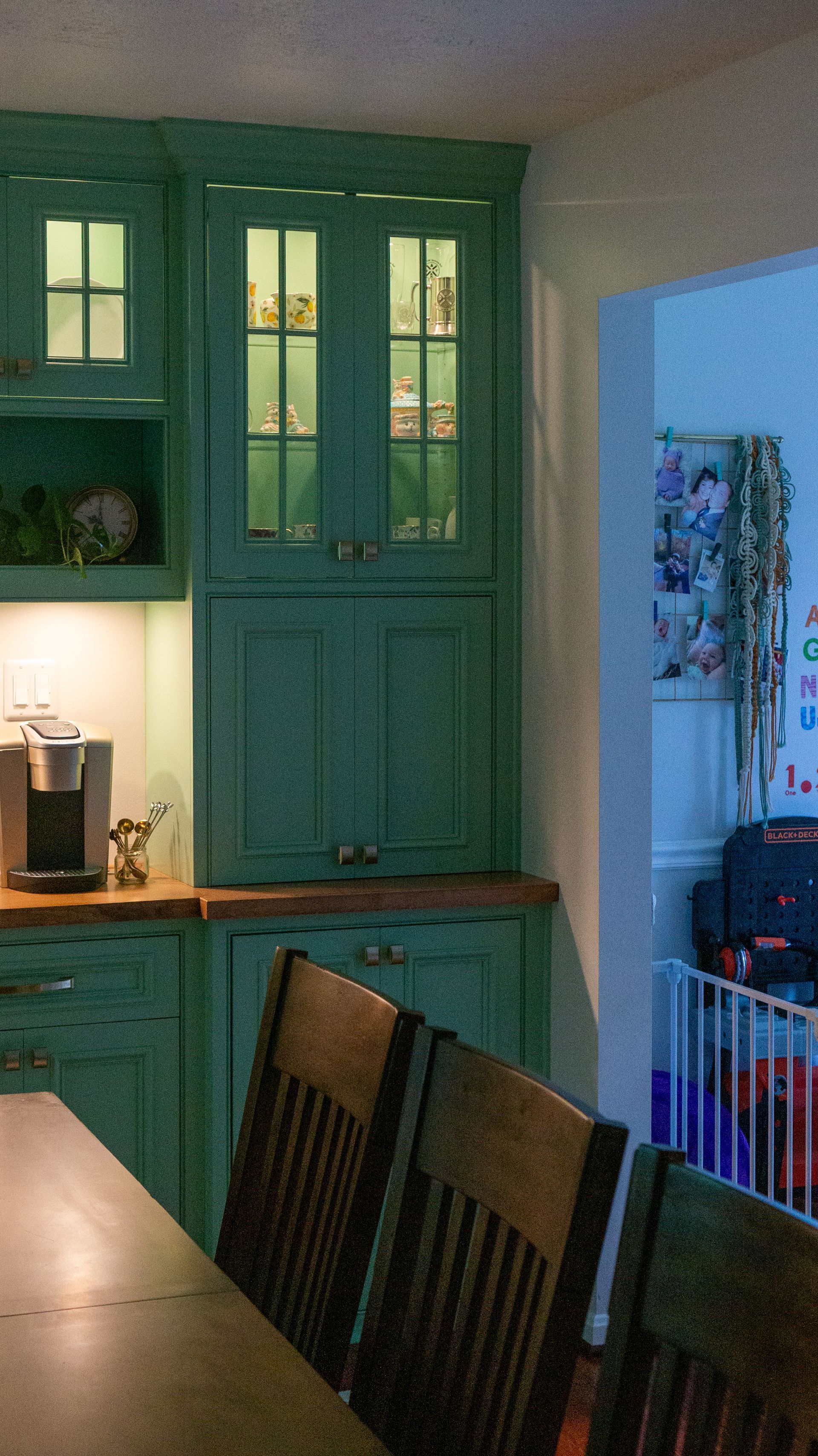 A kitchen with green cabinets and a table and chairs
