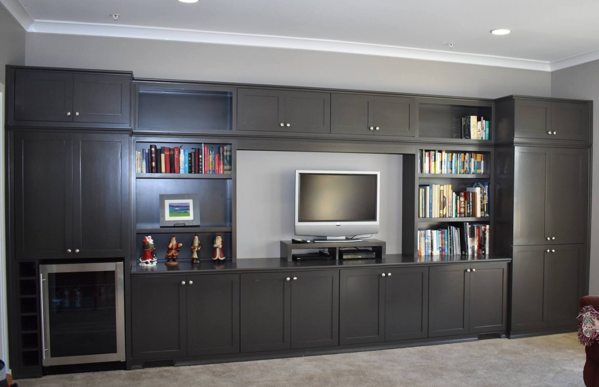 A living room with lots of cabinets and a flat screen tv