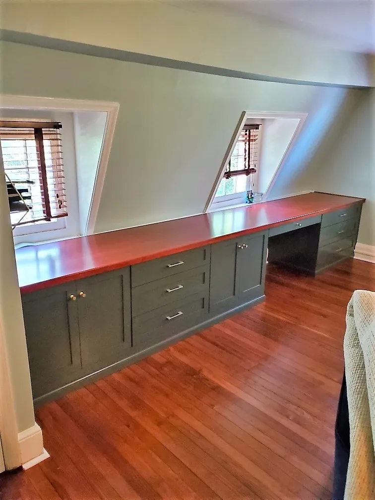 A room with hardwood floors and a desk in the corner