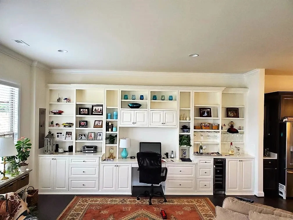 A living room with white cabinets and a rug