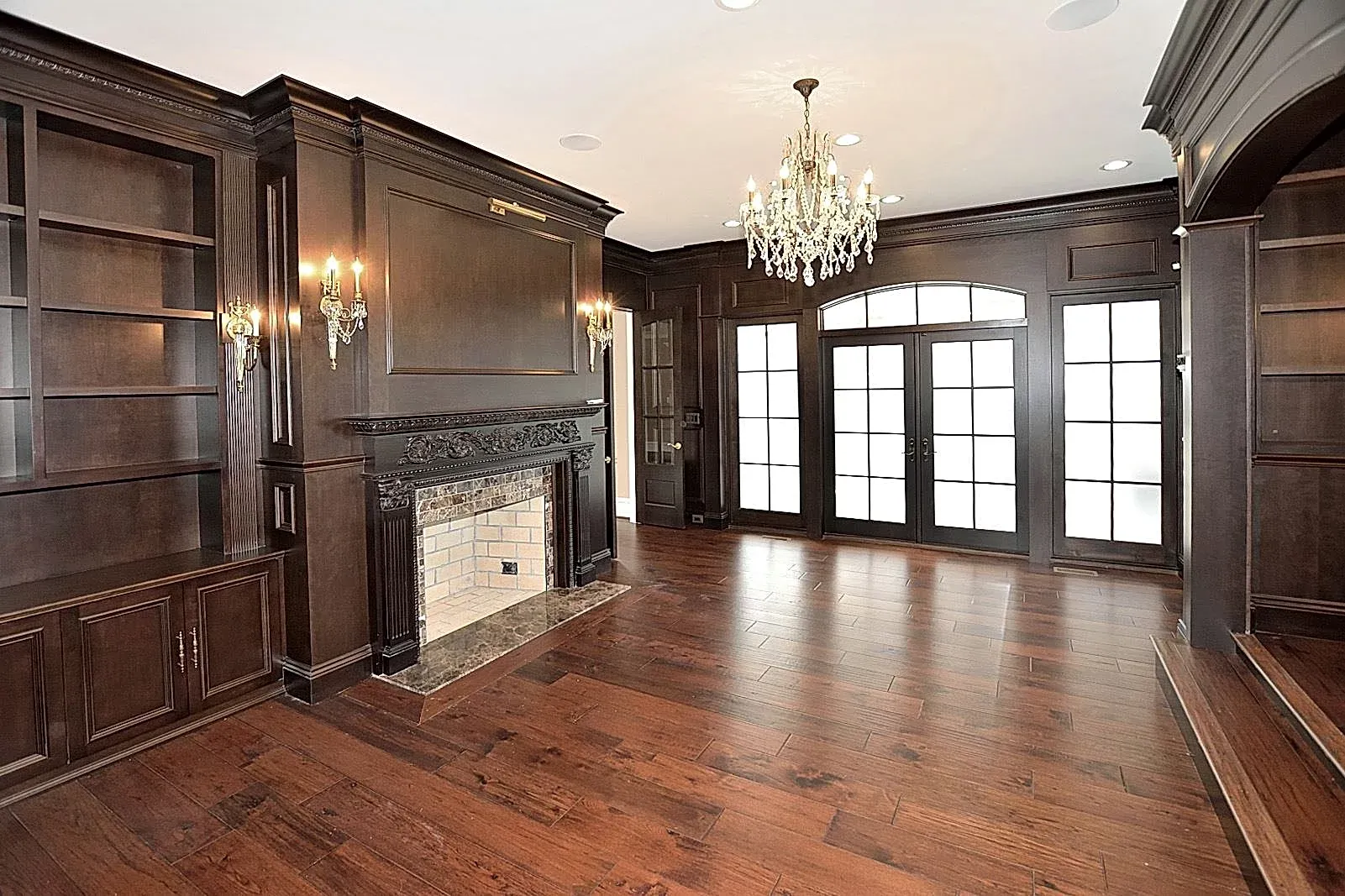 An empty room with a fireplace and a chandelier