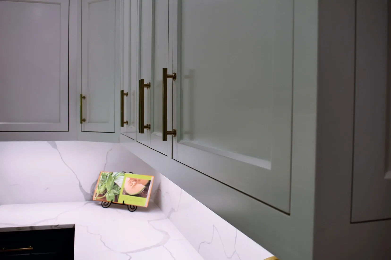 A kitchen with white cabinets and a picture on the counter
