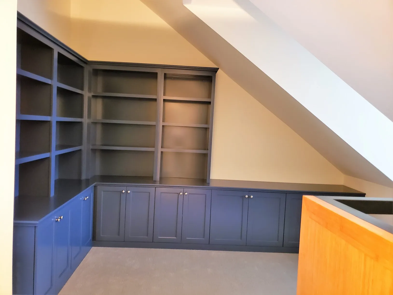 A corner of a room with blue cabinets and shelves
