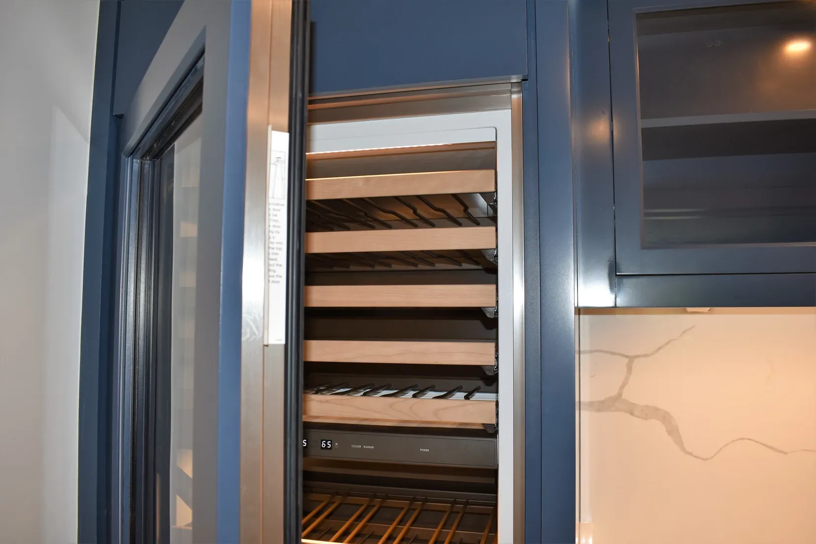 A wine cooler in a kitchen with the door open