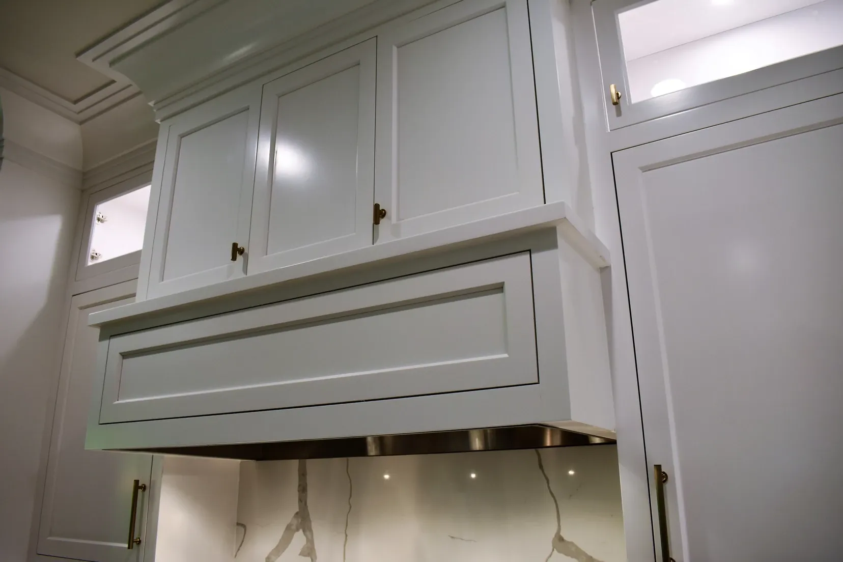 A kitchen with white cabinets and stainless steel appliances
