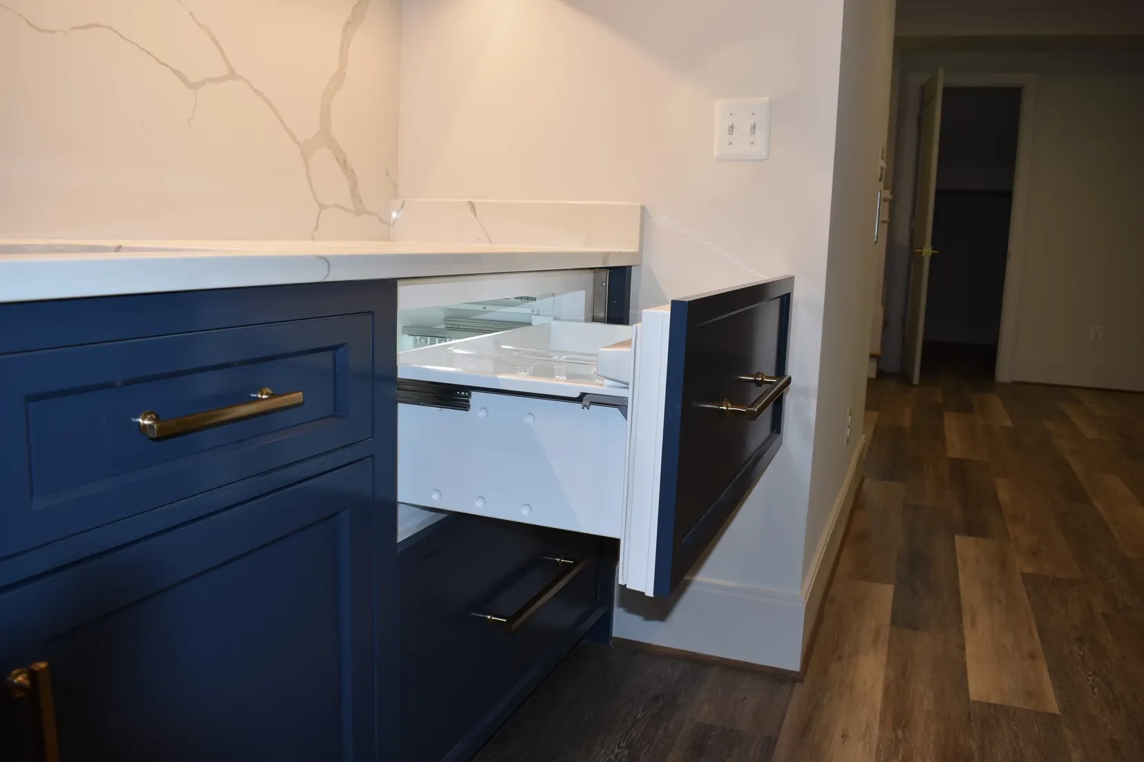 A kitchen with blue cabinets and a drawer open