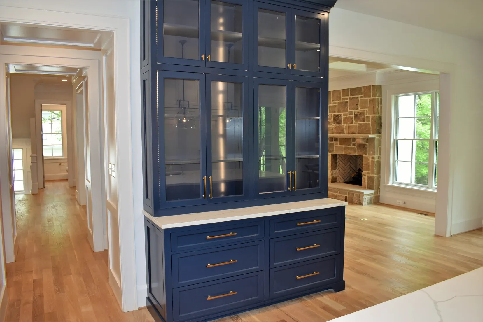 A blue cabinet with glass doors and drawers in a living room