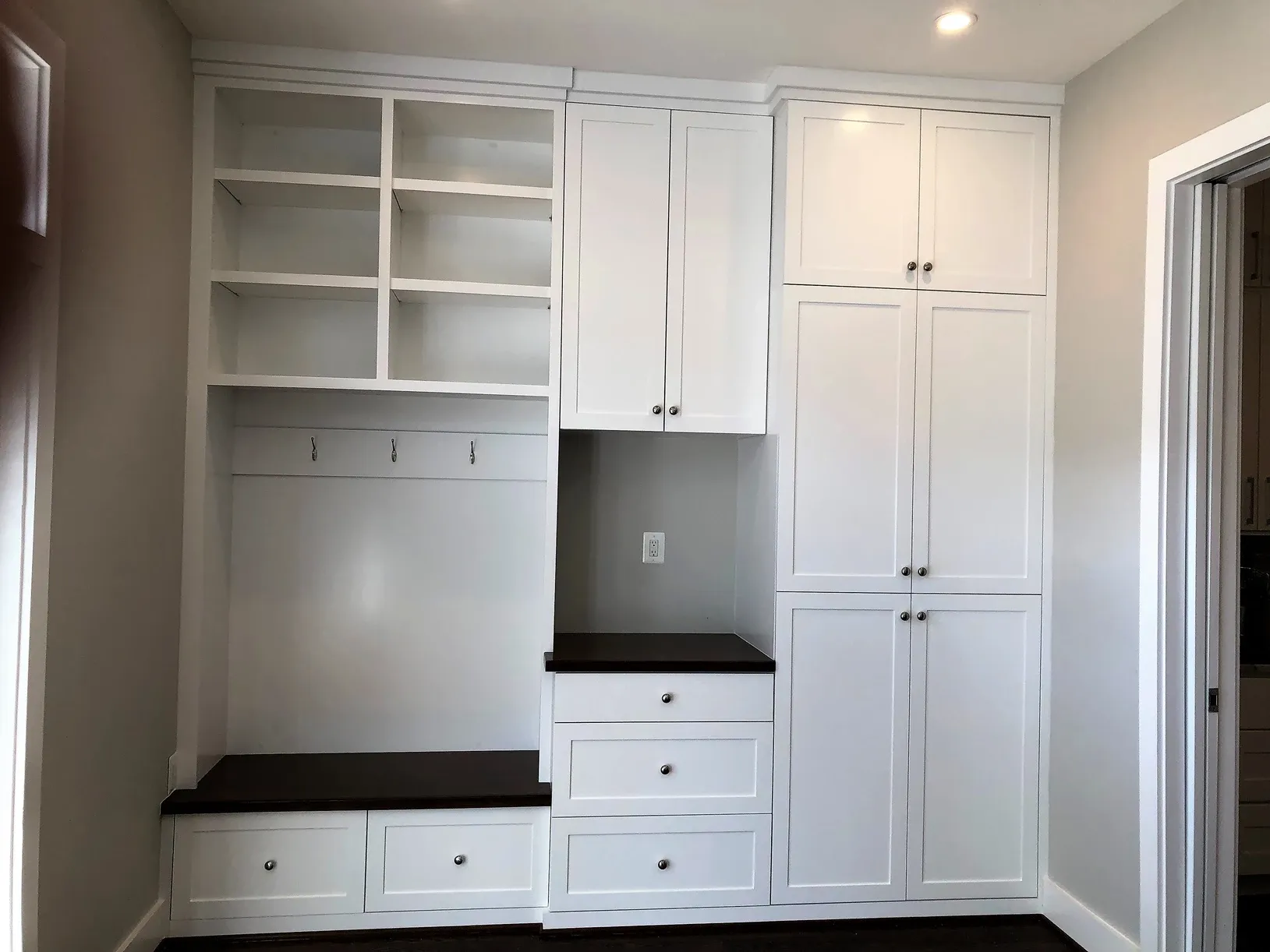 A room with lots of white cabinets and drawers