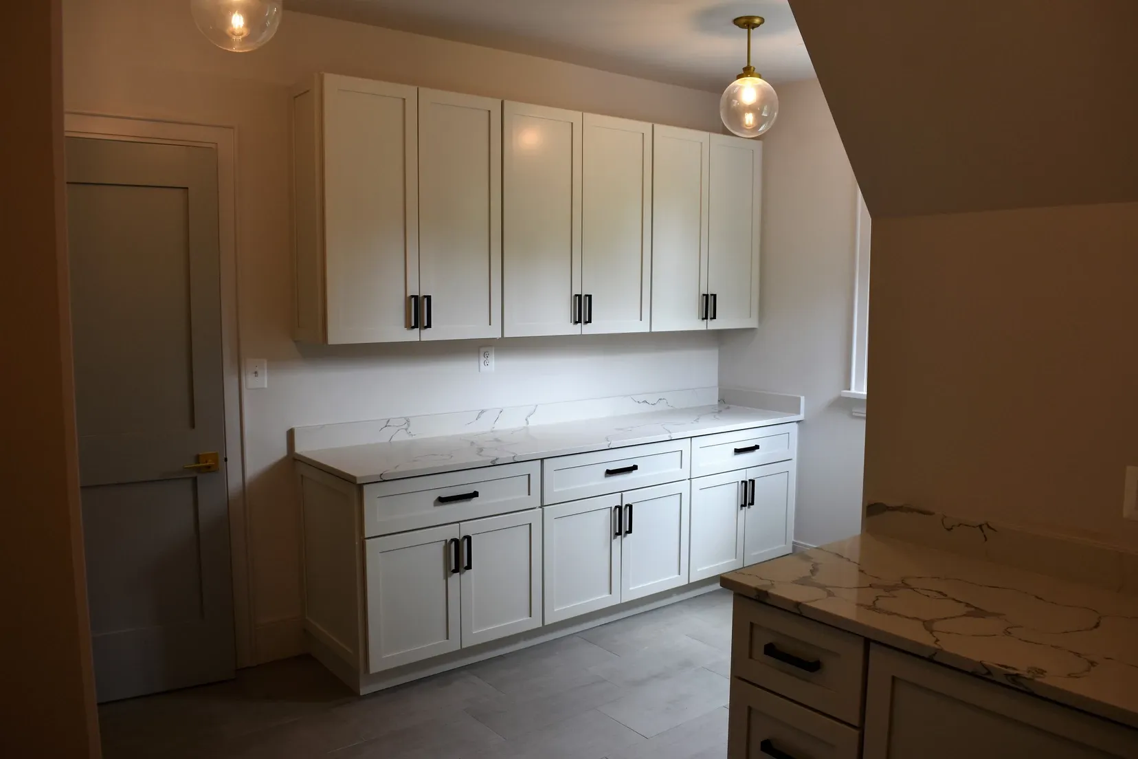 A kitchen with white cabinets and granite counter tops