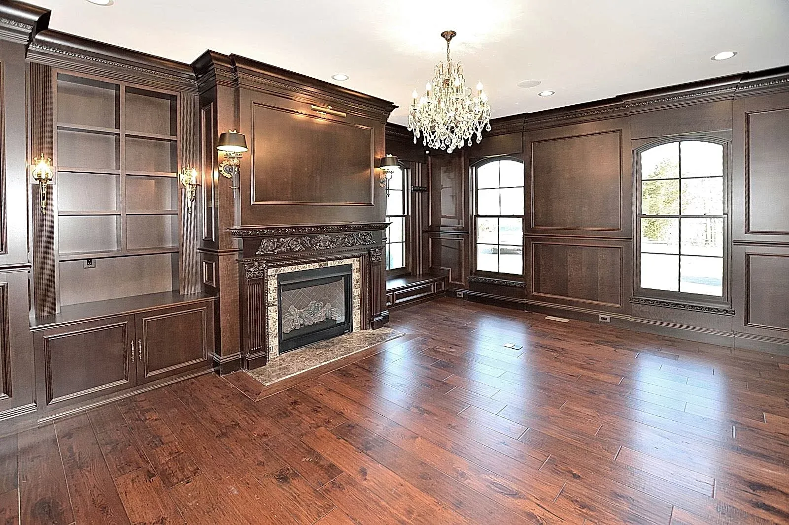 An empty room with a fireplace and a chandelier