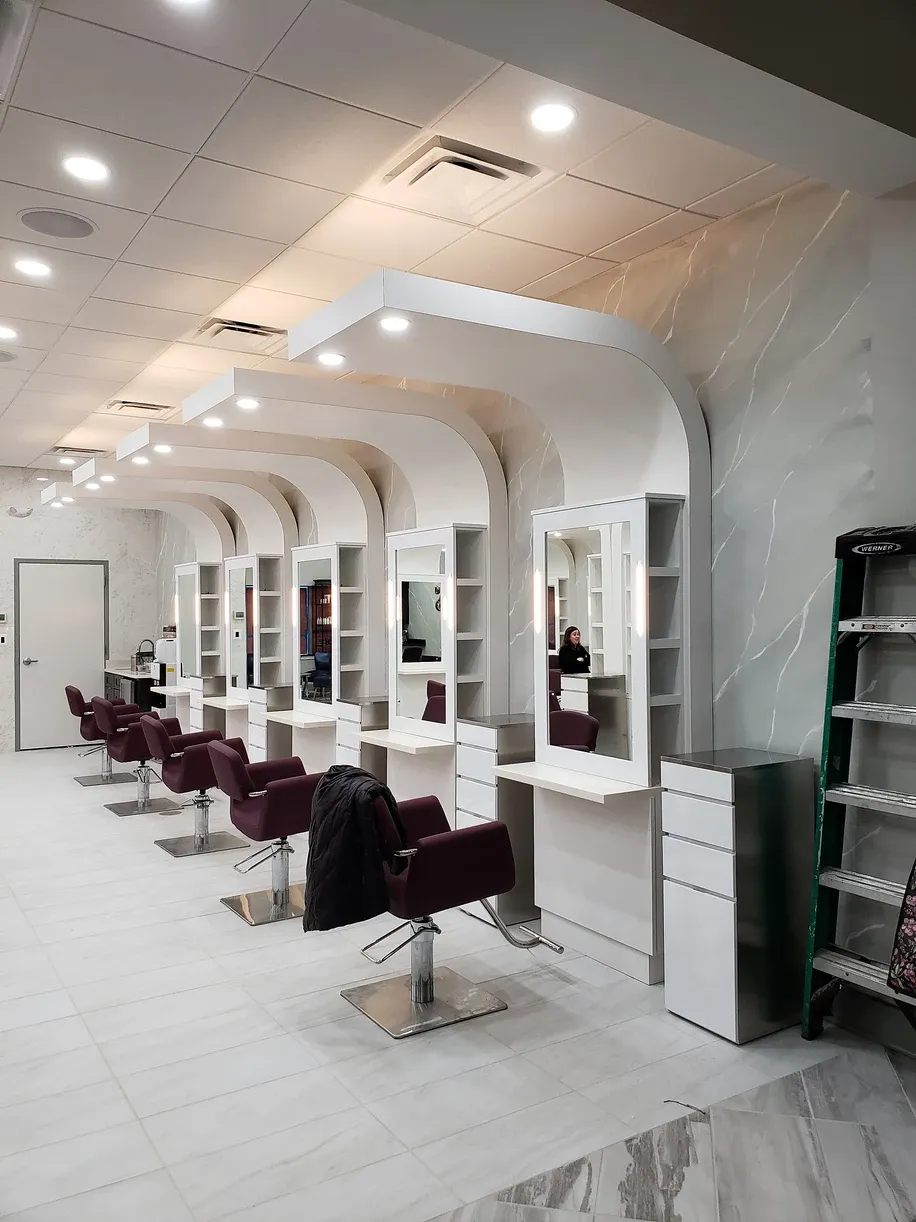 A row of hair salon chairs are lined up in a row