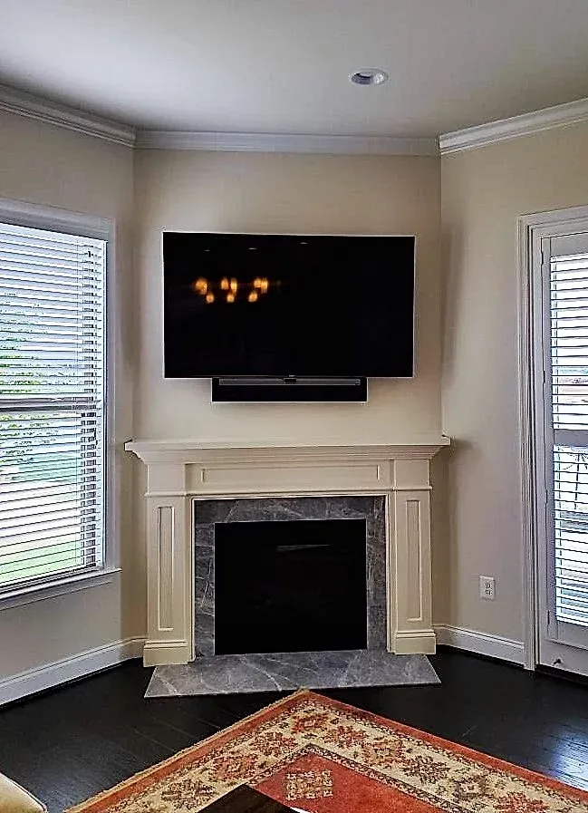 A living room with a fireplace and a flat screen tv