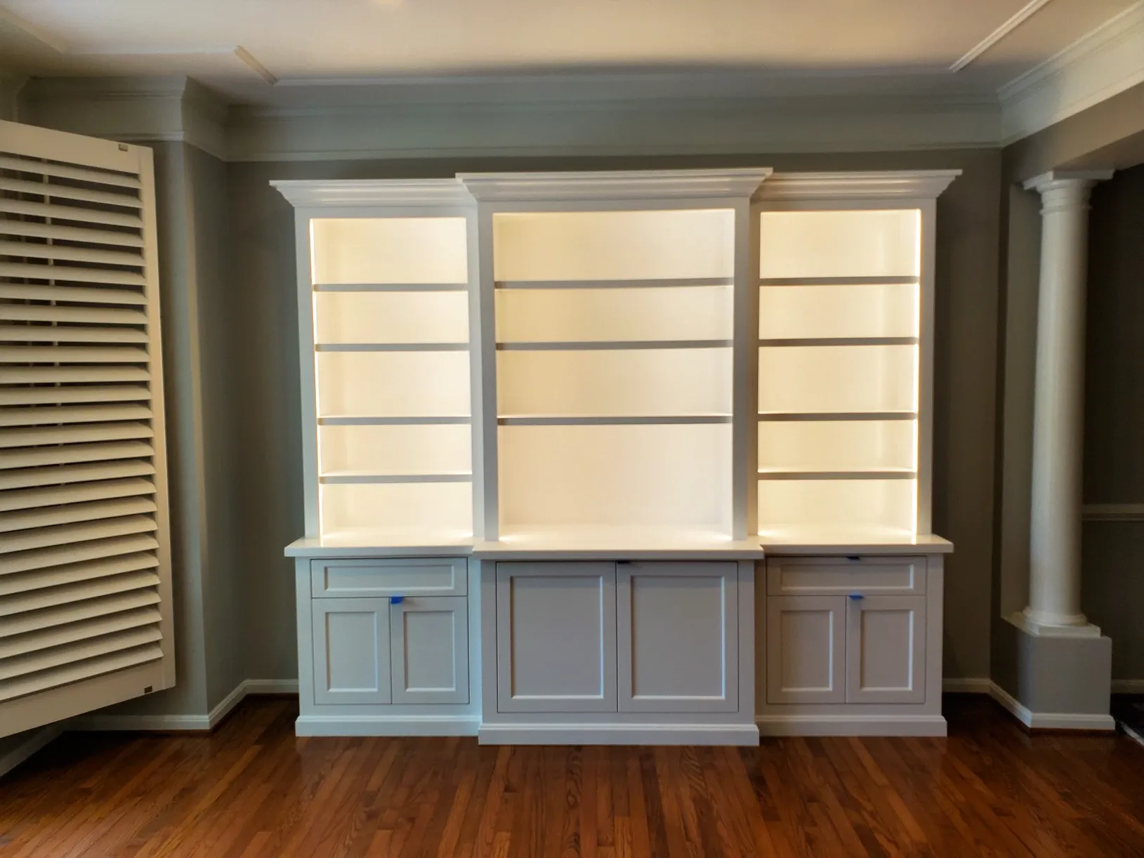 An empty room with white cabinets and shelves