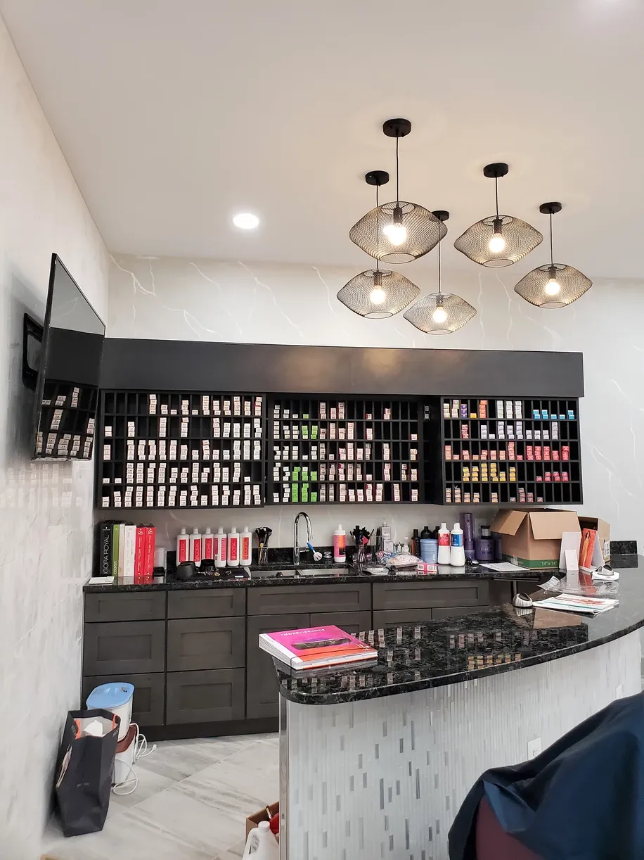 A kitchen with lots of bottles and a tv on the wall