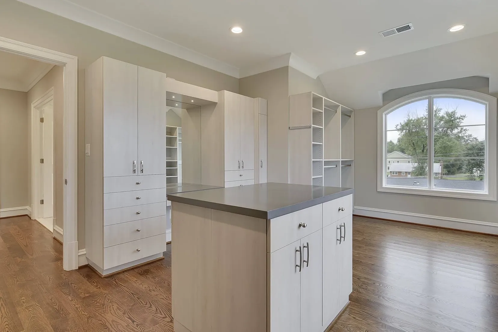 An empty kitchen with white cabinets and a large island