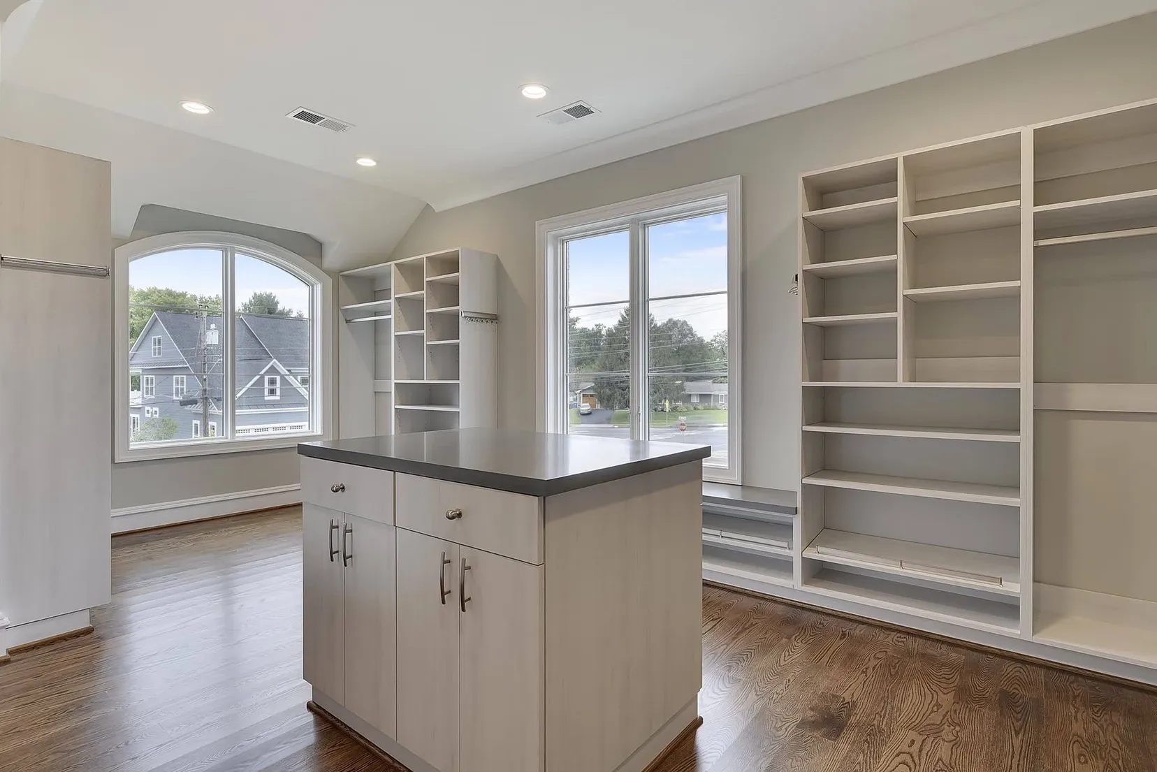 A kitchen with a large island and lots of shelves