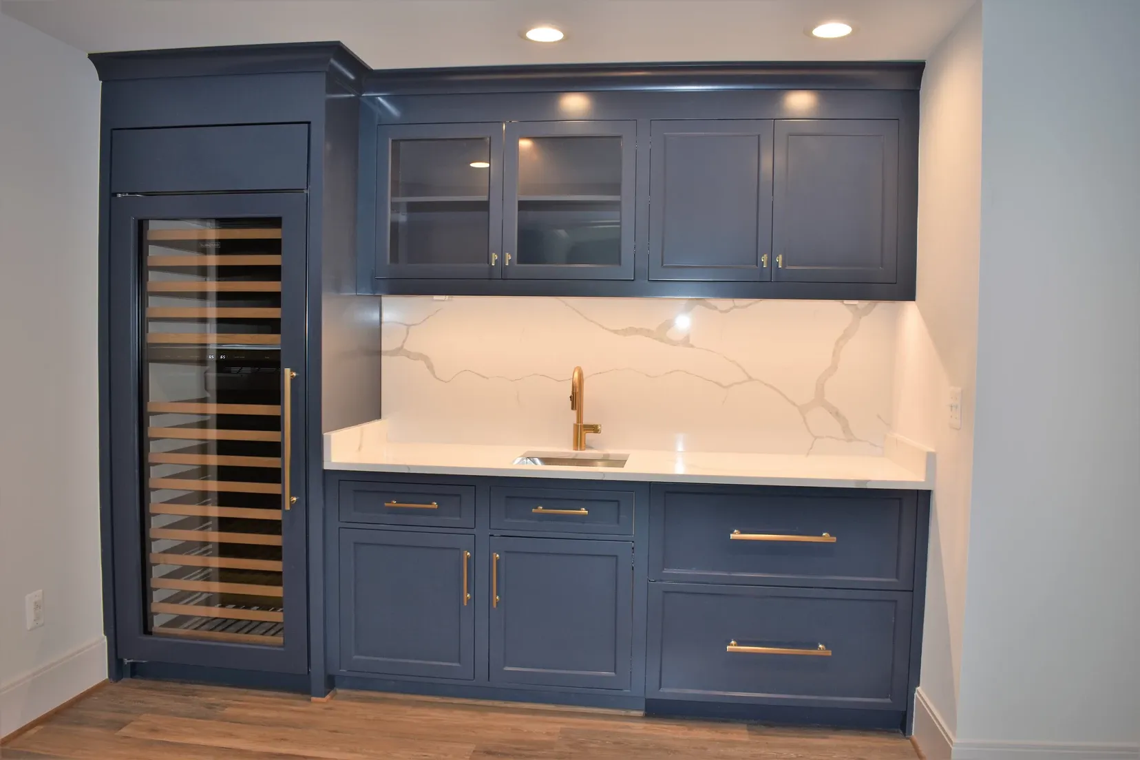 A kitchen with blue cabinets and a wine cooler