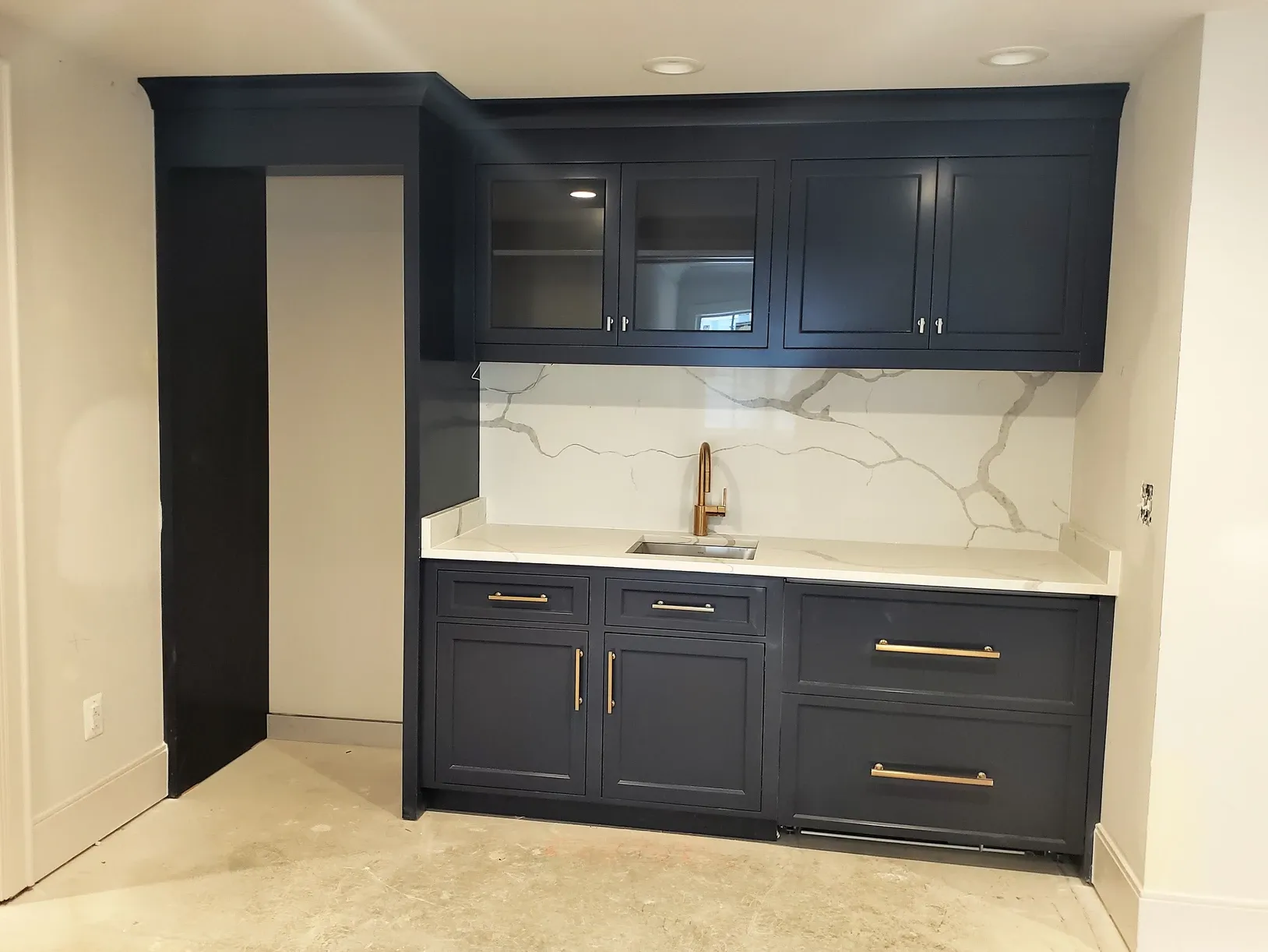 A kitchen with blue cabinets and white counter tops