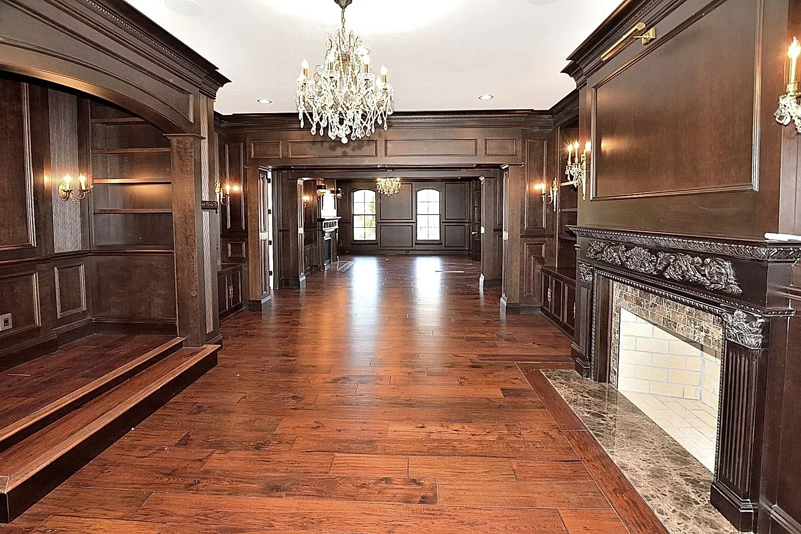 A long hallway with hardwood floors and a fireplace