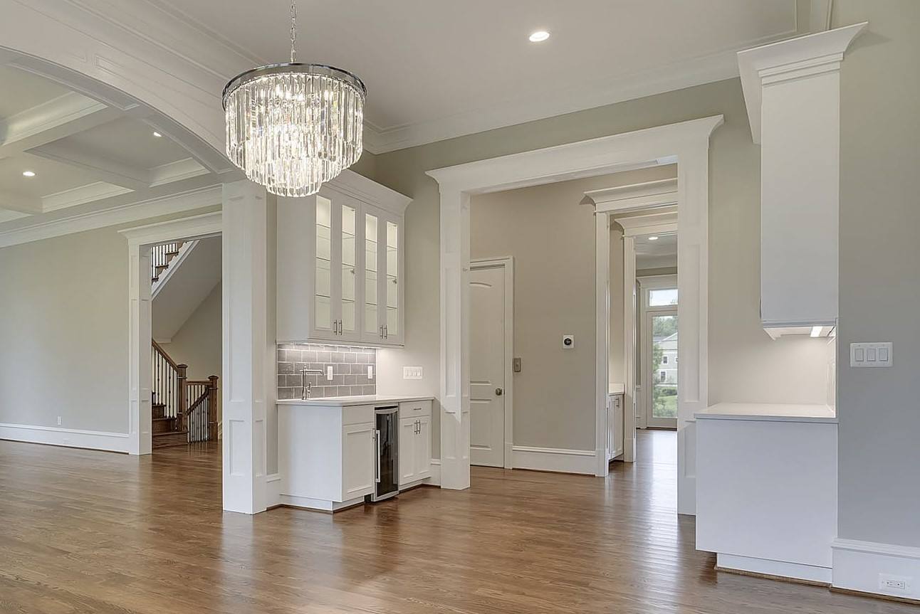 An empty house with a chandelier hanging from the ceiling