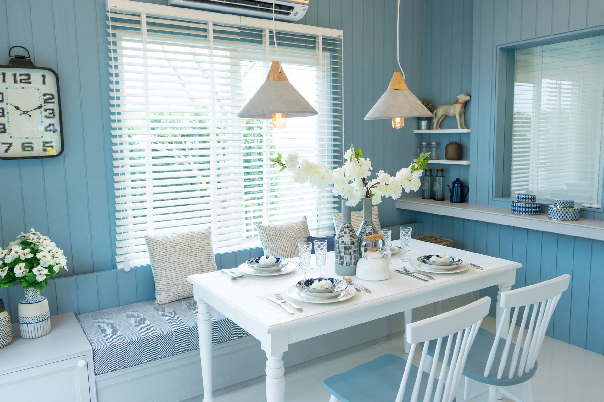 A beach condo featuring a kitchen with blue walls, light gray details, and crisp white furniture