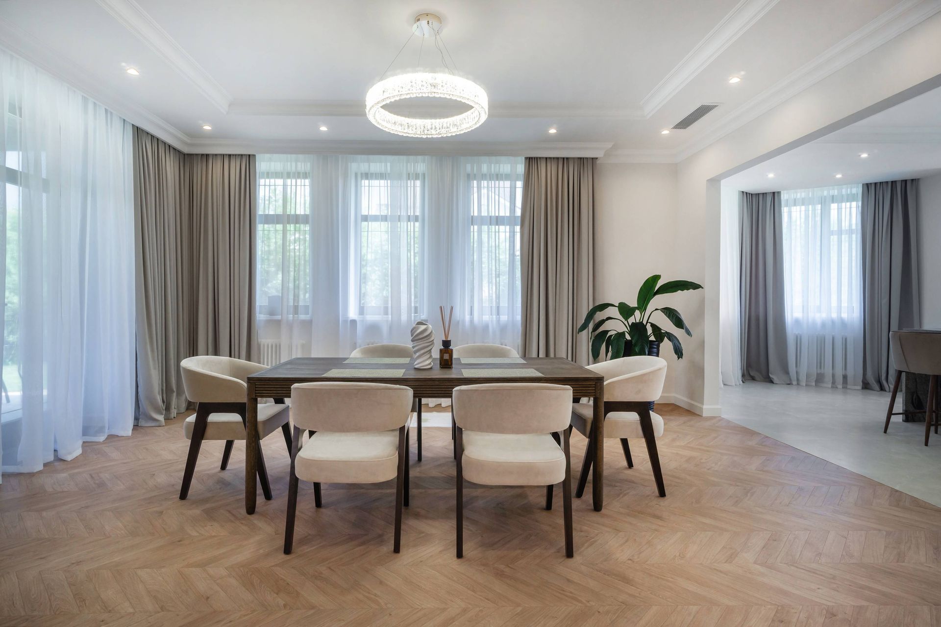 Layered window treatments in a dining room that has a traditional and elegant interior design style