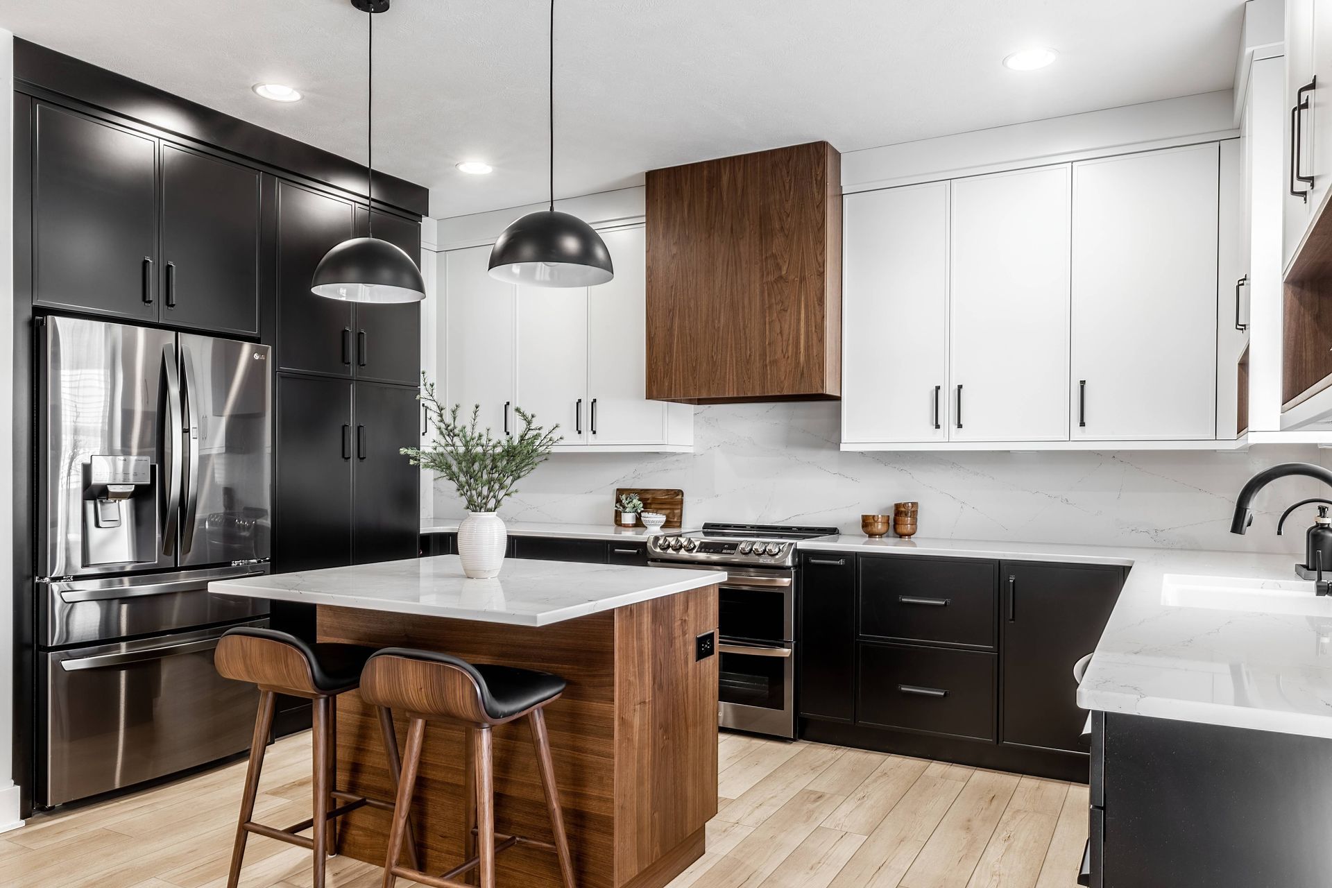 A contemporary interior designed kitchen with contrasting black and white colors and wood tones near