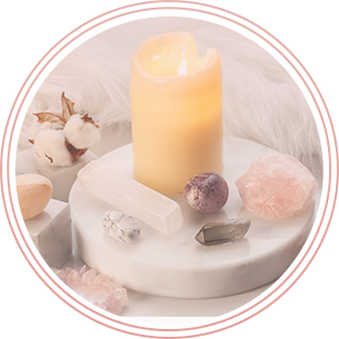 A candle is sitting on top of a white plate surrounded by crystals.