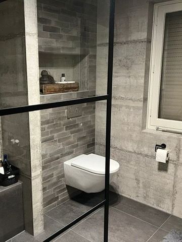 Een badkamer met toilet en raam.