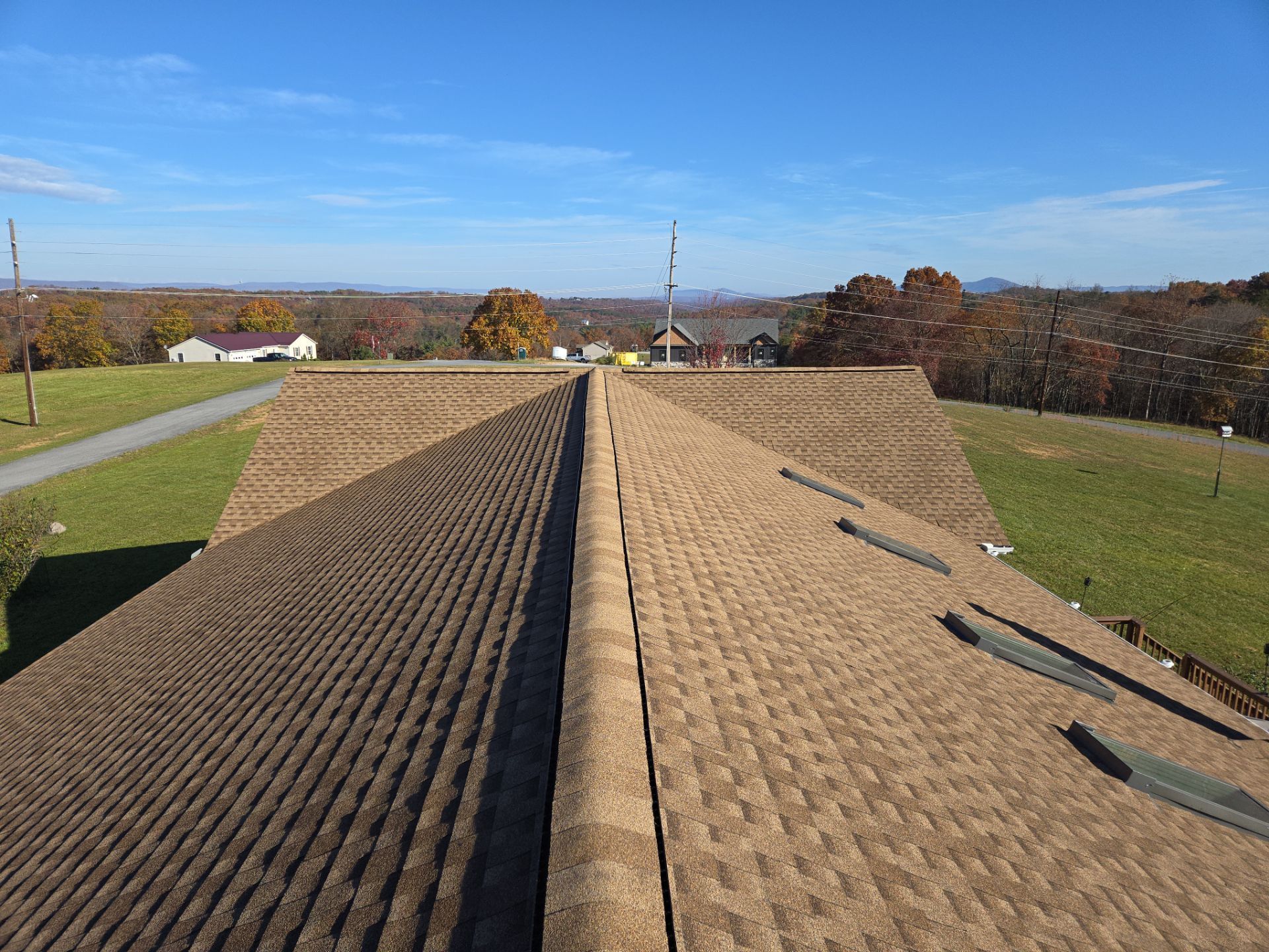The roof of a house with a view of a field.