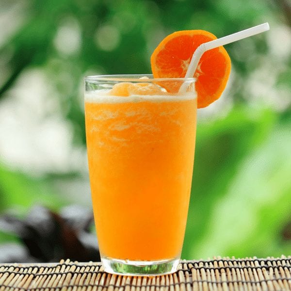 a glass of orange juice with a straw and an orange slice on top