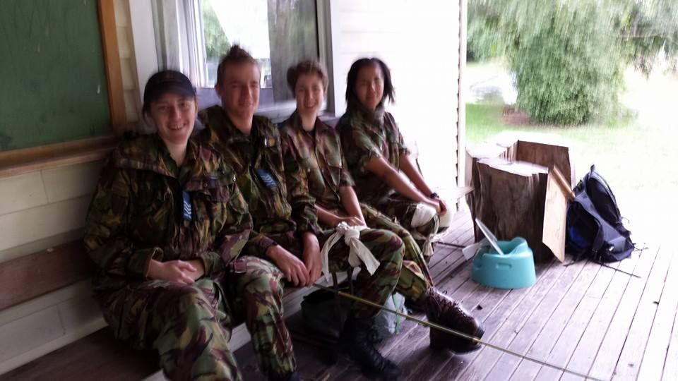 A group of people are standing in a circle with their arms around each other.