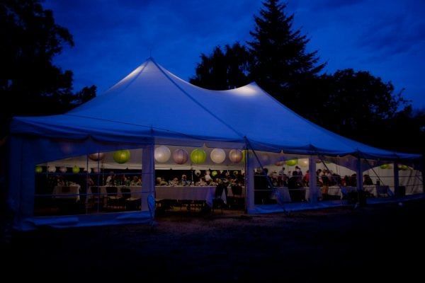 A large white tent is lit up at night.