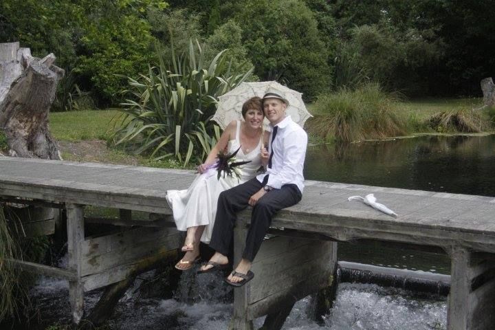 A bride and groom are holding a bouquet of flowers.