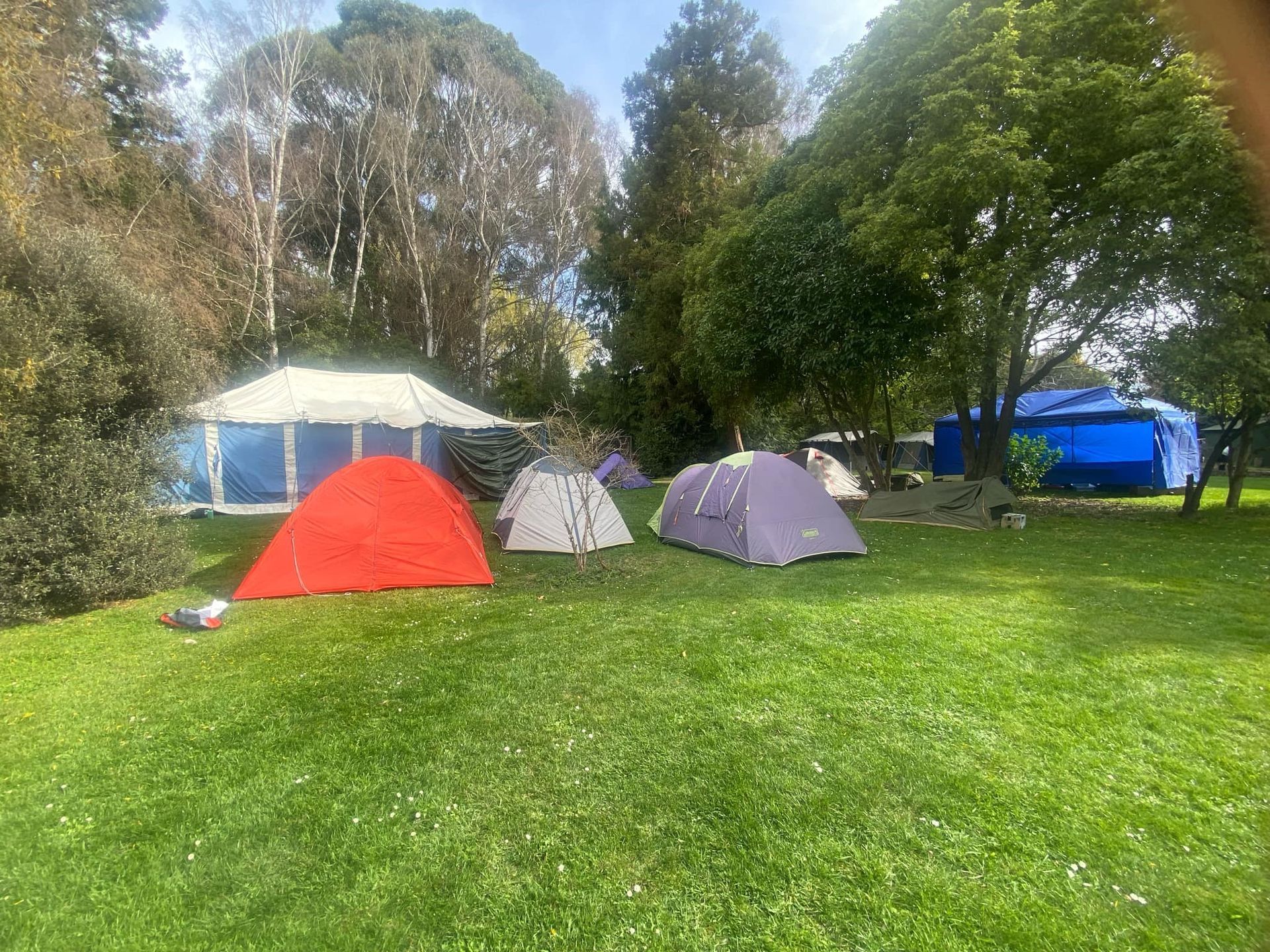 A group of tents are sitting on top of a lush green field.